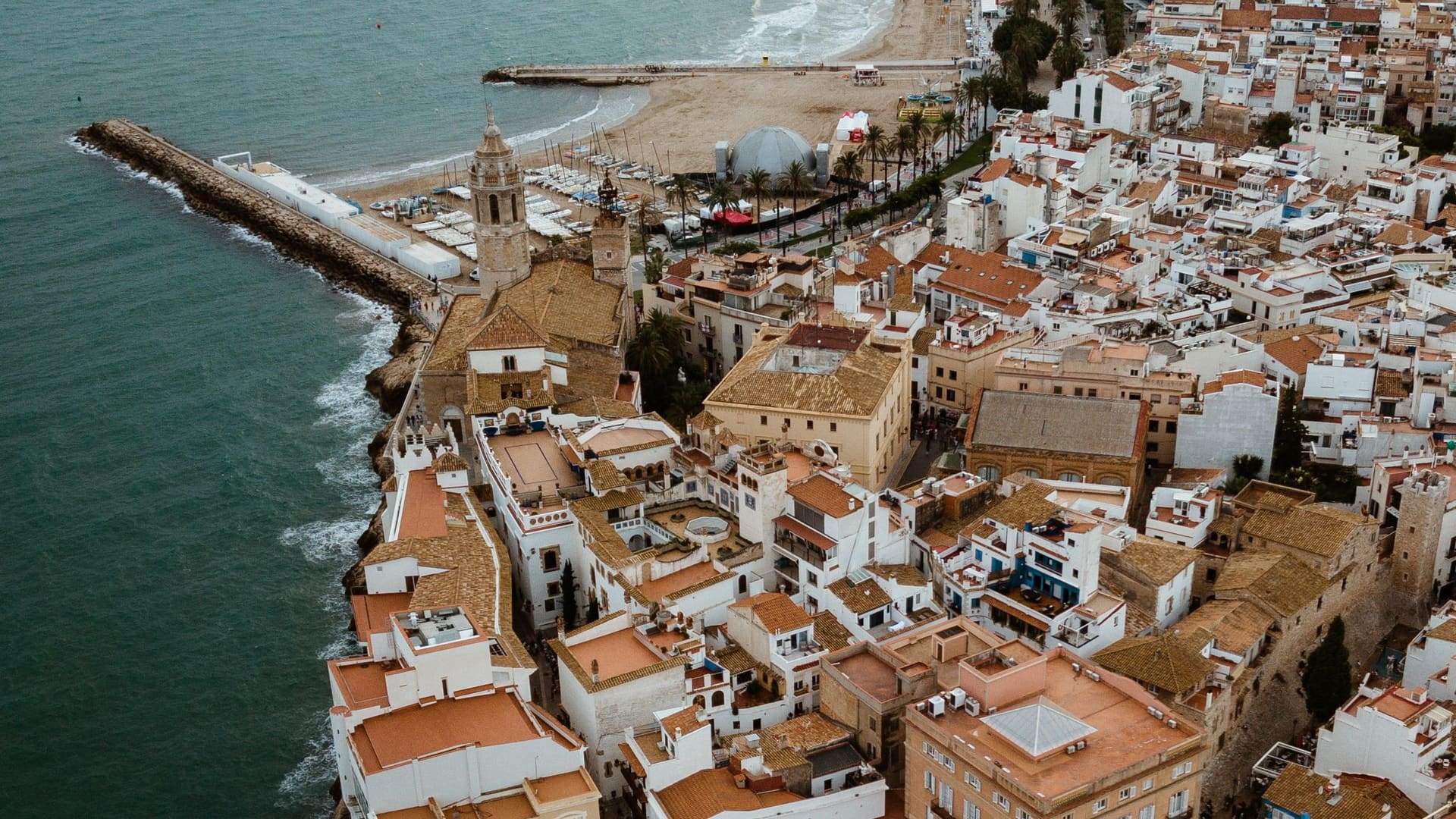 Sitges old town and seafront from the air, compared with Barcelona in this guide to where to live