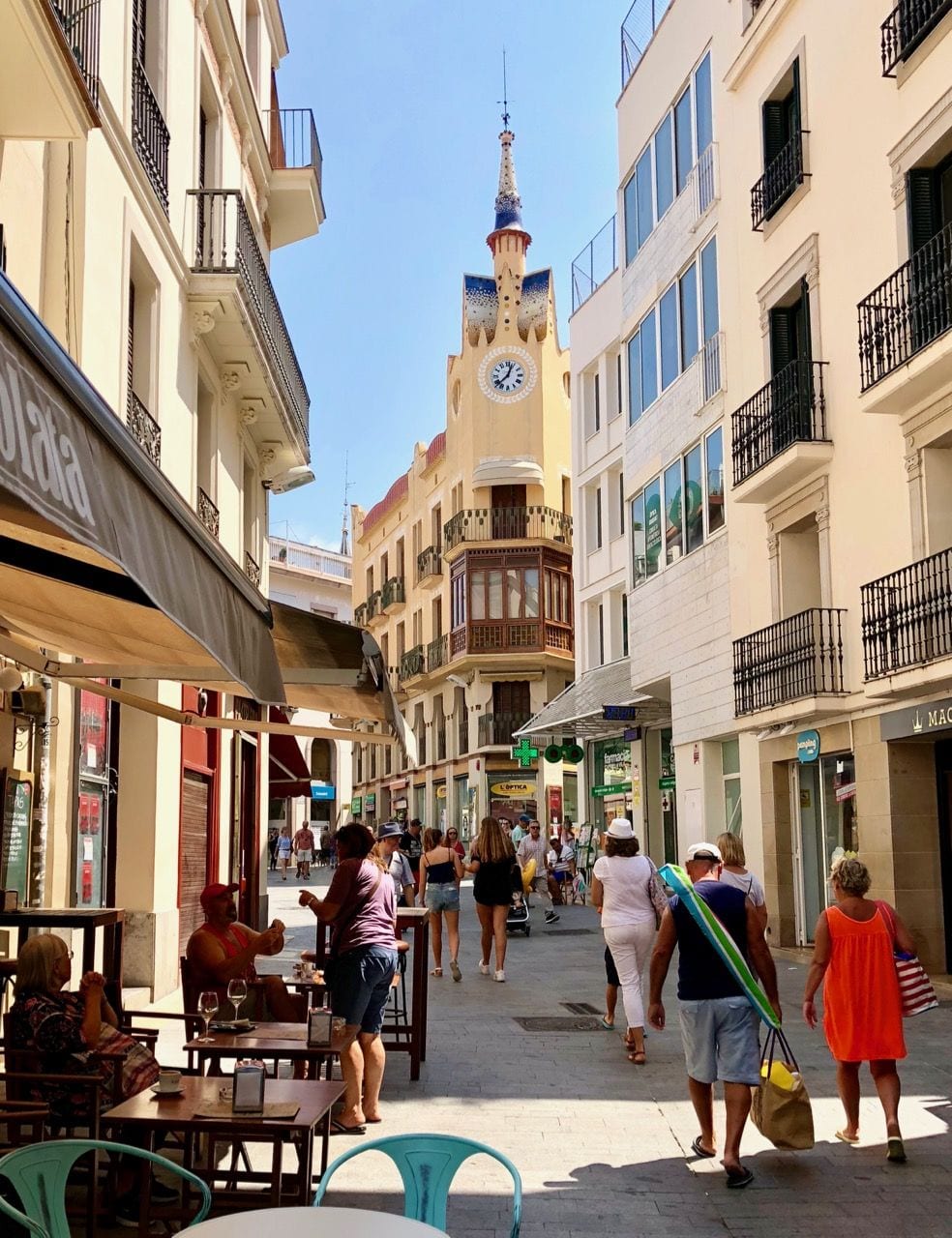 Carrer Major, Sitges: a pedestrian shopping street with café terraces facing the Cap de la Vila clock-tower building